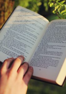 Buchsatz für Selfpublisher: Nahaufnahme Buch mit Hand im Grünen